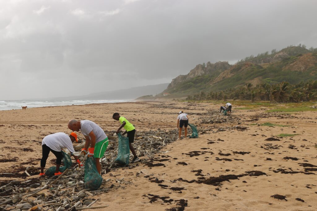 community volunteering at the beach with six people picking up trash