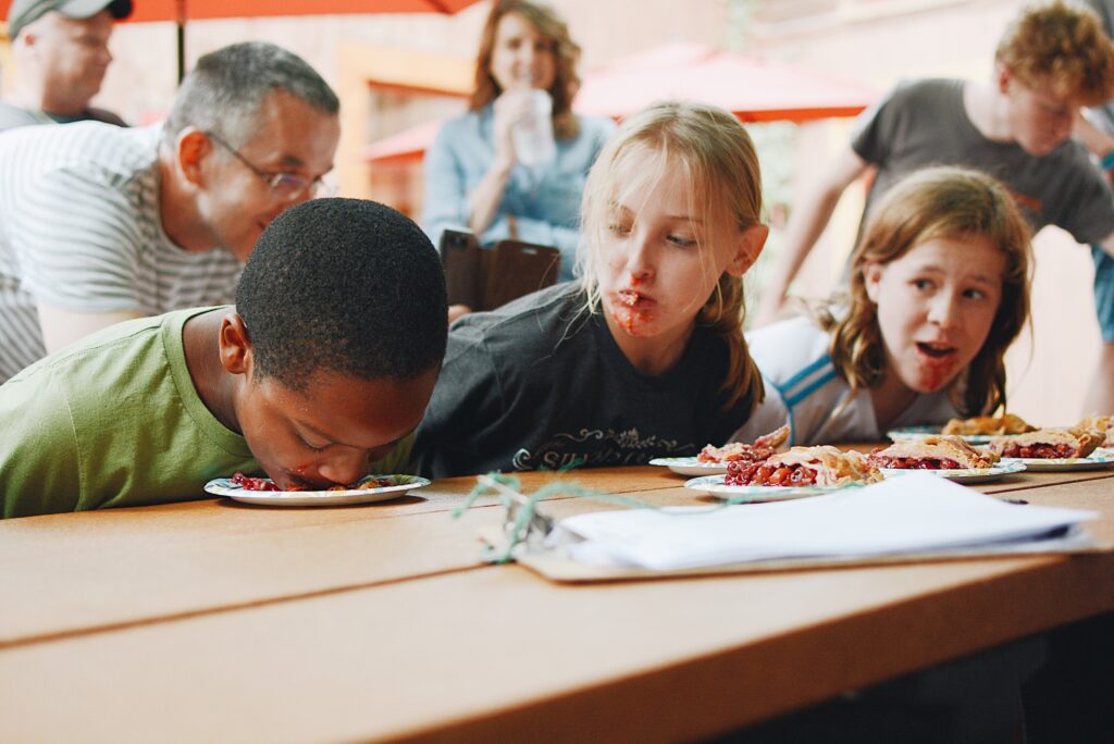 Pie eating contest with kids who have pie on their faces